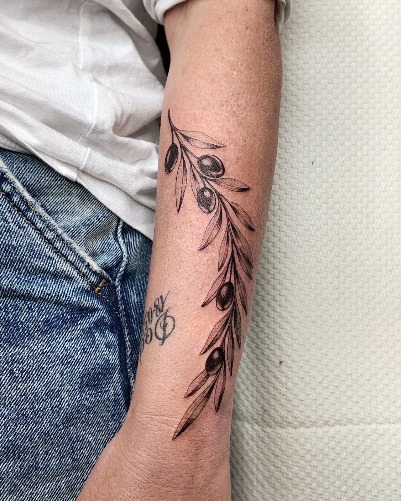 Tatouage fine line, branche fleurie le long du bras